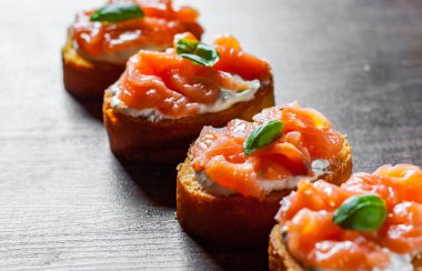 Ahşap masa arka plan üzerinde füme somon ve krem peynirli kanepeler