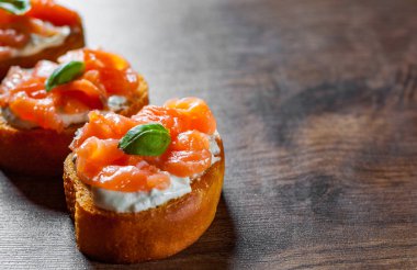 Ahşap masa arka plan üzerinde füme somon ve krem peynirli kanepeler