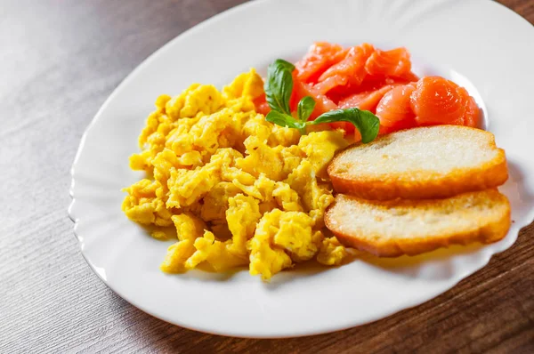 Rührei Mit Räucherlachs Und Toast Auf Weißem Teller Auf Holztischhintergrund — Stockfoto