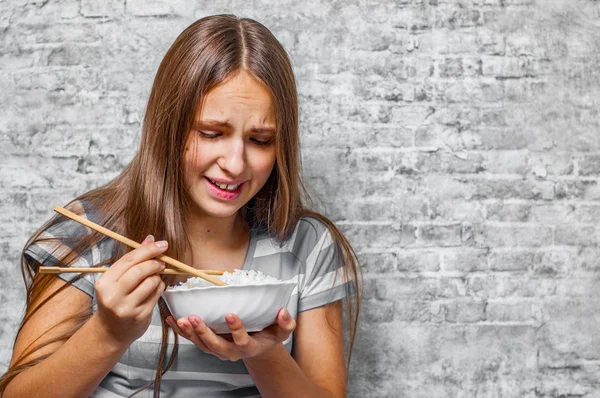 灰色背景下长头发吃米饭的青少年黑发女孩画像 — 图库照片