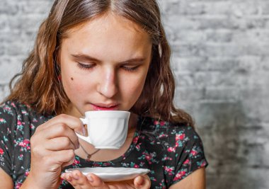 uzun saçlı bir fincan espresso kahve gri duvar arka planda tutan genç Genç esmer kız portresi