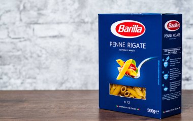 Minsk, Beyaz Rusya - 24 Kasım 2018: Barilla Penne Rigate İtalyan makarna kopya alanı gri duvar zemin üzerine ahşap masa üzerinde bir kutu içinde