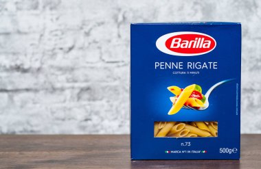Minsk, Beyaz Rusya - 24 Kasım 2018: Barilla Penne Rigate İtalyan makarna kopya alanı gri duvar zemin üzerine ahşap masa üzerinde bir kutu içinde