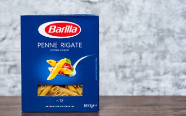 Minsk, Beyaz Rusya - 24 Kasım 2018: Barilla Penne Rigate İtalyan makarna kopya alanı gri duvar zemin üzerine ahşap masa üzerinde bir kutu içinde
