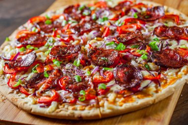 Biberli Pizza Mozzarella peyniri, salam, domates sosu, biber, soğan, baharat. Ahşap masa arka plan üzerinde İtalyan pizza