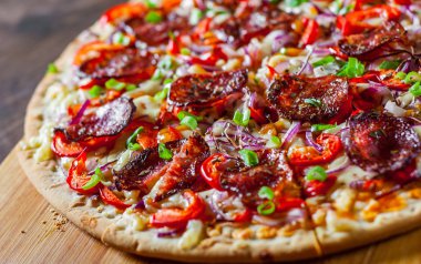 Biberli Pizza Mozzarella peyniri, salam, domates sosu, biber, soğan, baharat. Ahşap masa arka plan üzerinde İtalyan pizza