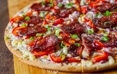 Biberli Pizza Mozzarella peyniri, salam, domates sosu, biber, soğan, baharat. Ahşap masa arka plan üzerinde İtalyan pizza