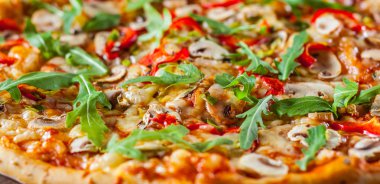 Vejetaryen Pizza Mozzarella peyniri, mantar, domates sosu, biber, baharat ve taze roka. Ahşap masa arka plan üzerinde İtalyan pizza