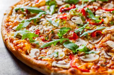 Vejetaryen Pizza Mozzarella peyniri, mantar, domates sosu, biber, baharat ve taze roka. Ahşap masa arka plan üzerinde İtalyan pizza