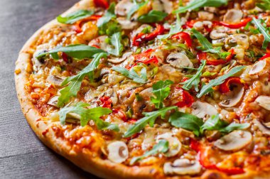 Vejetaryen Pizza Mozzarella peyniri, mantar, domates sosu, biber, baharat ve taze roka. Ahşap masa arka plan üzerinde İtalyan pizza