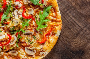Vejetaryen Pizza Mozzarella peyniri, mantar, domates sosu, biber, baharat ve taze roka. Ahşap masa arka plan üzerinde İtalyan pizza