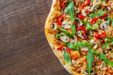 Vejetaryen Pizza Mozzarella peyniri, mantar, domates sosu, biber, baharat ve taze roka. Ahşap masa arka plan üzerinde İtalyan pizza