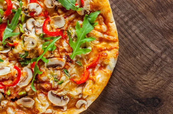 Vejetaryen Pizza Mozzarella peyniri, mantar, domates sosu, biber, baharat ve taze roka. Ahşap masa arka plan üzerinde İtalyan pizza
