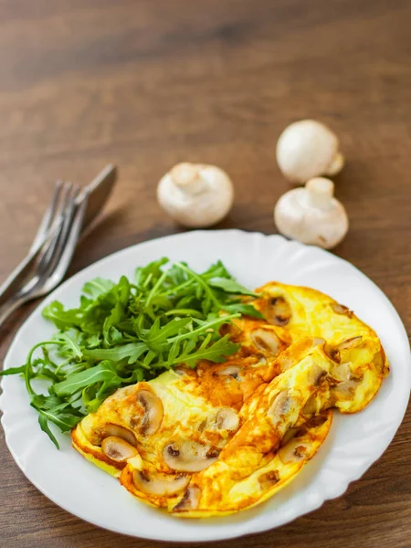 Omelet Con Funghi Insalata Rucola Piatto Bianco Sfondo Tavolo Legno — Foto Stock