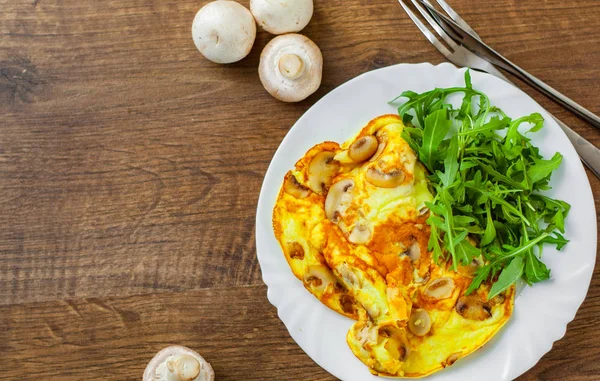 Omelett Mit Pilzen Und Rucolasalat Weißem Teller Auf Holztischhintergrund — Stockfoto