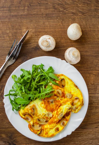 Omelett Mit Pilzen Und Rucolasalat Weißem Teller Auf Holztischhintergrund — Stockfoto