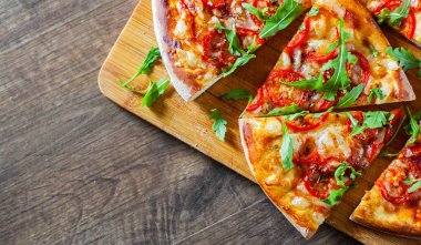 Vejetaryen Pizza Mozzarella peyniri, domates, biber, baharat ve taze roka ile dilim. İtalyan pizza. Pizza Margherita veya ahşap masa arka plan üzerinde Margarita