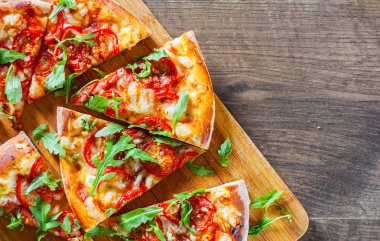 Vejetaryen Pizza Mozzarella peyniri, domates, biber, baharat ve taze roka ile dilim. İtalyan pizza. Pizza Margherita veya ahşap masa arka plan üzerinde Margarita