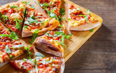 Vejetaryen Pizza Mozzarella peyniri, domates, biber, baharat ve taze roka ile dilim. İtalyan pizza. Pizza Margherita veya ahşap masa arka plan üzerinde Margarita