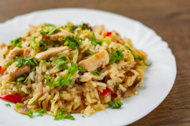 Pirinç, mantar ve ahşap masa arka plan üzerinde beyaz tabak sebze ile tavuk göğsü