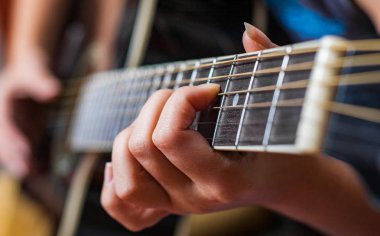Genç kadın el Siyah akustik gitar çalmaya closeup