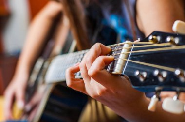 Genç kadın el Siyah akustik gitar çalmaya closeup