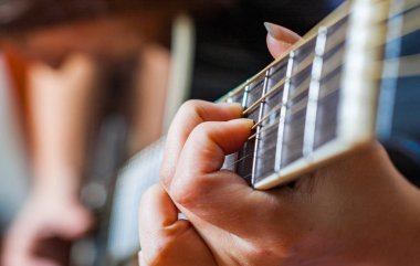 Genç kadın el Siyah akustik gitar çalmaya closeup