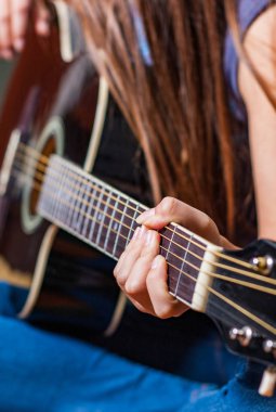 Genç kadın el Siyah akustik gitar çalmaya closeup