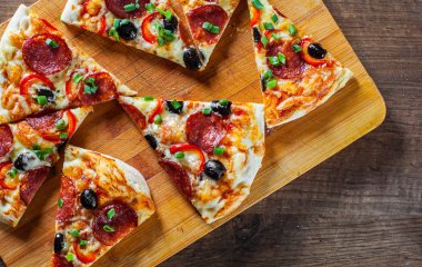 Pizza Mozzarella peyniri, sucuk, domates, biber, zeytin, salam. Ahşap masa arka plan üzerinde İtalyan pizza