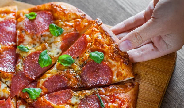 Kobieta Ręka Bierze Kawałek Pizzy Pepperoni Serem Mozzarella Salami Pomidory — Zdjęcie stockowe