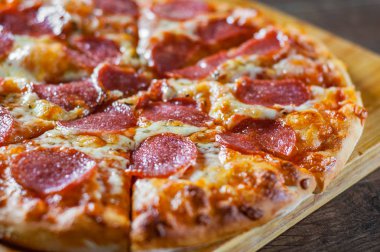 Pepperoni Pizza Mozzarella peyniri, salam, domates, biber. Ahşap masa arka plan üzerinde İtalyan pizza