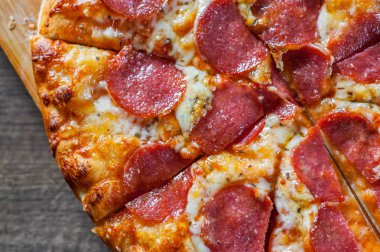 Pepperoni Pizza Mozzarella peyniri, salam, domates, biber. Ahşap masa arka plan üzerinde İtalyan pizza