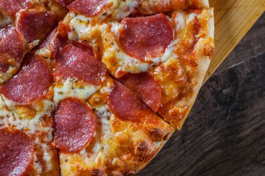Pepperoni Pizza Mozzarella peyniri, salam, domates, biber. Ahşap masa arka plan üzerinde İtalyan pizza