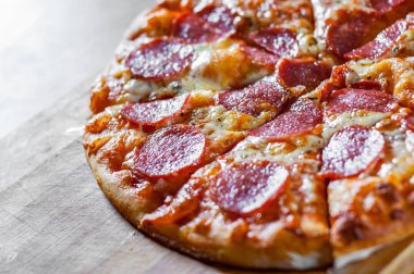Pepperoni Pizza Mozzarella peyniri, salam, domates, biber. Ahşap masa arka plan üzerinde İtalyan pizza