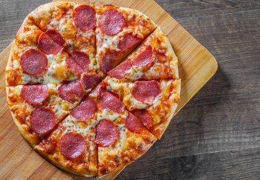 Pepperoni Pizza Mozzarella peyniri, salam, domates, biber. Ahşap masa arka plan üzerinde İtalyan pizza