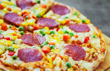 Sebze karışımı, Mozzarella peyniri, sucuk, domates, salam pizza. Ahşap masa arka plan üzerinde İtalyan pizza