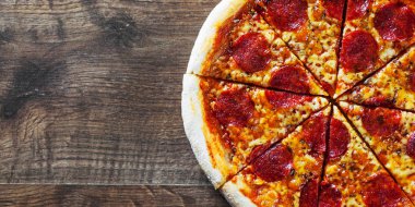 Pepperoni Pizza Mozzarella peyniri, salam, domates, biber. Ahşap masa arka plan üzerinde İtalyan pizza