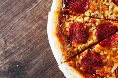 Pepperoni Pizza Mozzarella peyniri, salam, domates, biber. Ahşap masa arka plan üzerinde İtalyan pizza