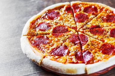 Pepperoni Pizza Mozzarella peyniri, salam, domates, biber. Ahşap masa arka plan üzerinde İtalyan pizza