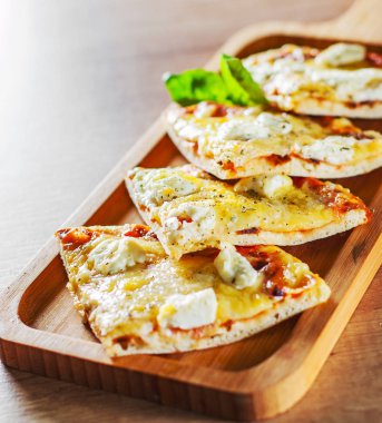 Pizza Mozzarella peyniri ile dilimlenmiş, domates, biber, baharat ve taze fesleğen. İtalyan pizza. Pizza Margherita veya ahşap masa arka plan üzerinde Margarita
