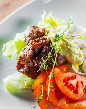 kızarmış sığır filetosu beyaz tabakta sebze salatası ile parça