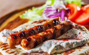 ızgara et sosis pide ekmek ve sebze salatası ve cacık ile daldırma ahşap tahta üzerinde
