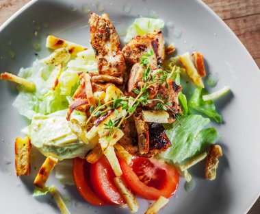 kızarmış tavuk göğsü parça fileto beyaz tabakta sebze salatası ile