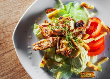 kızarmış tavuk göğsü parça fileto beyaz tabakta sebze salatası ile