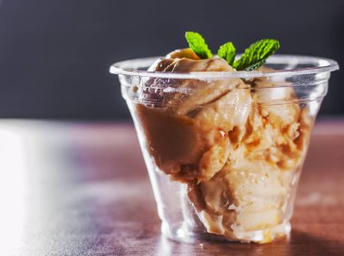 Creme Brulee dondurma nane yaprağı ile plastik bir kap içinde
