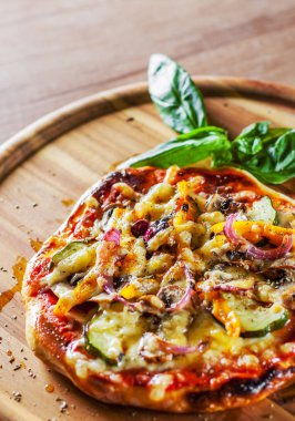 vejetaryen pizza Mozzarella peynir, kızarmış kabak, mantar, kırmızı soğan, biber ve taze fesleğen. Ahşap masa arka plan üzerinde İtalyan pizza