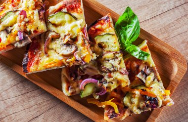 vejetaryen pizza Mozzarella peyniri, ızgara kabak, mantar, kırmızı soğan, biber ve taze fesleğen dilimlenmiş. Ahşap masa arka plan üzerinde İtalyan pizza
