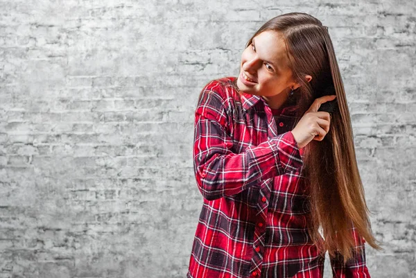 Портрет Юной Брюнетки Подростка Длинными Волосами Расчесывая Волосы Сером Фоне — стоковое фото