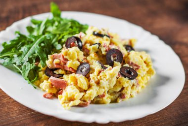 omlet jambon, zeytin ve Roka Salatası ahşap masa arka plan üzerinde beyaz plaka ile