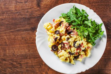 omlet jambon, zeytin ve Roka Salatası ahşap masa arka plan üzerinde beyaz plaka ile